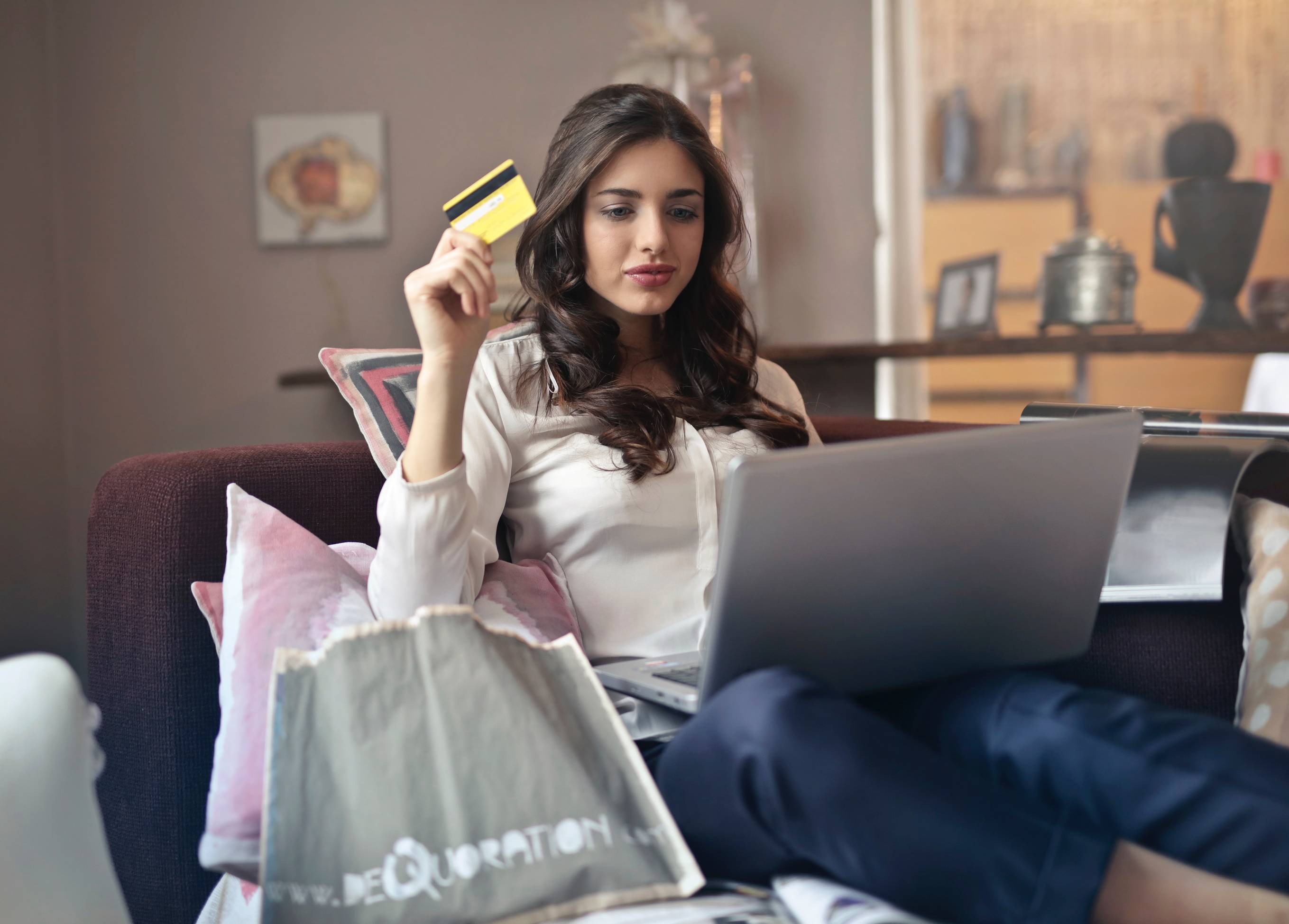 mulher-sentada-no-sofa-comprando-online-comparando-preços